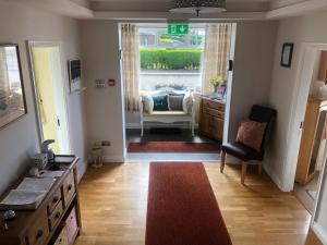 a hallway with a living room with a couch and a window at Drumcoo Guest House in Enniskillen