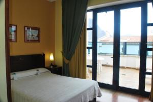 Un dormitorio con una cama y vista a un balcón. en Hotel Puerto de Las Nieves, en Agaete