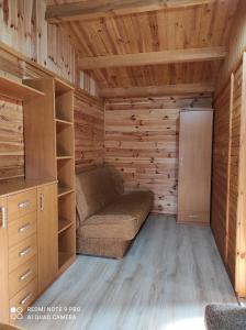 a small room with a couch and a refrigerator at Domki letniskowe "DORCIA" in Łeba