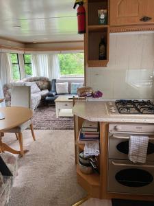 a kitchen and living room with a stove and a couch at Caravan at Charleston House in Inverness