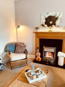 a living room with a fireplace with a cow on the wall at The Ramblers Rest - whole apartment - pet friendly - close to amenities and walks in Edzell