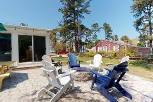 eine Gruppe von Stühlen und ein Tisch auf einer Terrasse in der Unterkunft Cape Cod Beach Cottage in Dennis