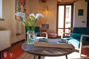 un salon avec une table et un vase de fleurs dans l'établissement Serafini Home 20 con piscina a 20km dal mare by Yohome, à Bargni