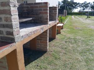 a brick retaining wall with benches in a yard at Las Casuarinas in Federación +21 photos