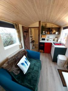 a living room with a couch in a tiny house at The Feathers Shepherds Hut in Áth Eascrach