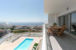 - un balcon avec une table et une piscine dans l'établissement Casa Urlaub, à Nazaré