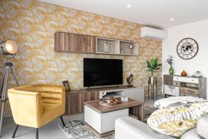 un salon avec une télévision à écran plat sur un mur dans l'établissement Casa Urlaub, à Nazaré