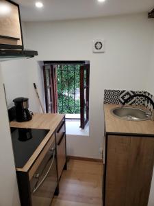 a kitchen with a sink and a counter top at Appartement cosy dans les ruelles de Pietranera in San-Martino-di-Lota