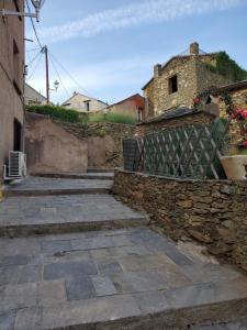 kamienny chodnik z kamienną ścianą i budynek w obiekcie Casa Straboni w mieście San-Martino-di-Lota