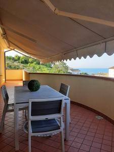 una mesa y sillas en un balcón con vistas al océano en Villa Paradiso, en Campofilone