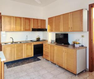 a kitchen with wooden cabinets and a sink at GAYA MARINA in Lido Marini