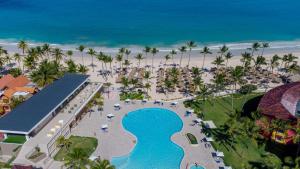 a beach scene with a large building and palm trees at Caribe Deluxe Princess - All Inclusive in Punta Cana
