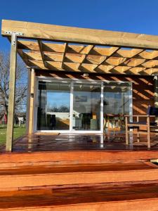 una terraza de madera con pérgola de madera en The Tiny Nest en Palmerston North