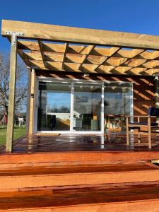 a wooden deck with a wooden pergola at The Tiny Nest in Palmerston North