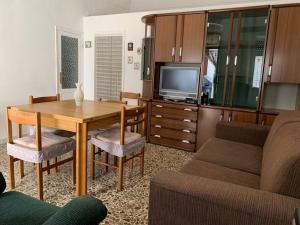 sala de estar con mesa de madera y TV en Casa Naneta, en San Martino in Pensilis