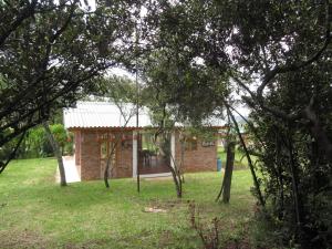 uma casa de tijolos no meio de um campo com árvores em Posada Rural, Colinas y Senderos em Paipa