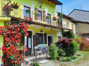 ein gelbes Haus mit einem Balkon mit roten Blumen in der Unterkunft Appartamento sul lago Maggiore in Castelletto sopra Ticino