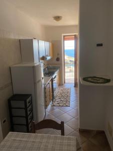 una cucina con frigorifero, lavandino e tavolo di Appartamenti Casa Conte a Ischia