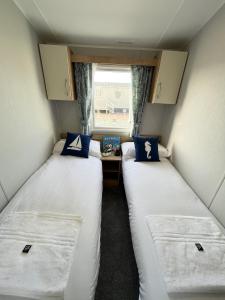 two beds in a small room with a window at Charming 2-Bed Cottage in Morecambe in Morecambe