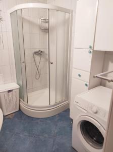 a bathroom with a shower and a washing machine at Apartment MM Split in Split