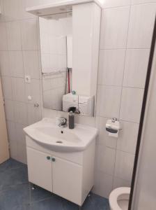 a white bathroom with a sink and a mirror at Apartment MM Split in Split