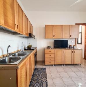 a kitchen with wooden cabinets and a sink at GAYA MARINA in Lido Marini