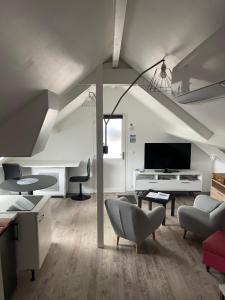 ein Wohnzimmer mit einem Sofa und einem TV in der Unterkunft Les Gîtes de La Maison Bleue d'Estialescq in Estialescq