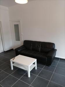 un soggiorno con divano nero e tavolino bianco di O'Couvent - Appartement 125 m2 - 5 chambres - A524 a Salins-les-Bains