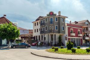 um carro estacionado em frente a um edifício numa rua em Hotel Pazari & Apartments em Korçë