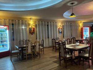 a dining room with tables and chairs in a restaurant at Pensiunea 1 Mai in Baile Unu Mai