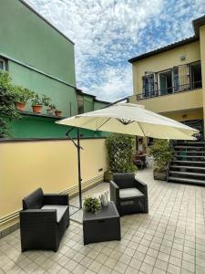 a patio with two chairs and an umbrella at Domus Silvana Apartments in Ravenna