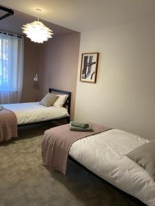 ein Schlafzimmer mit zwei Betten und einem Kronleuchter in der Unterkunft Modern apartment in central quiet York with free Parking - Contemporary new building in York