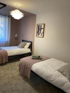 a bedroom with two beds and a chandelier at City Centre yet quiet -- Modern 2bed home with wine -- Parking 1 min walk in York