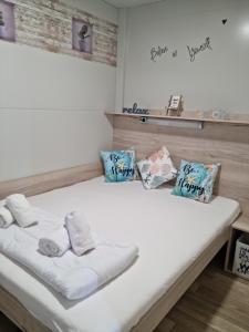 a white bed with towels and pillows on it at Sand & Relax Privlaka - Mobile home "Lavanda" in Privlaka