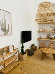 a living room with a couch and a table and a tv at Appartement Casadilonda - Casadibastia - Vue mer Citadelle in Bastia