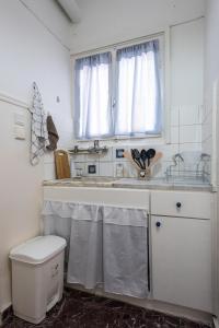 a bathroom with a sink and a toilet and a window at Melina Beachfront Apartment in Malaki