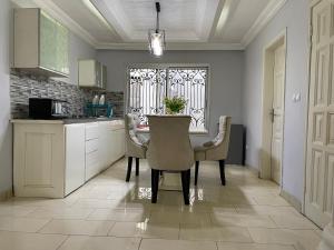 Résidence KHETY في ياوندي: مطبخ مع طاولة وكراسي ونافذة