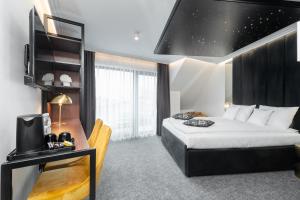 Pokój hotelowy z łóżkiem, biurkiem i telewizorem w obiekcie Axel Baltic Jacuzzi & Sauna w mieście Międzyzdroje
