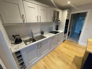a kitchen with white cabinets and a wooden floor at Sea View Lodge in Sligo