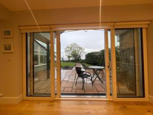 a sliding glass door leading to a patio with a table at Sea View Lodge in Sligo