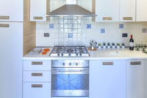 une cuisine blanche avec une cuisinière et un évier dans l'établissement Mafalda Apartments, à Levanto