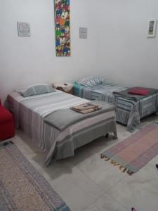 a room with two beds and a red chair at kitnet Maysa em Benfica RJ in Rio de Janeiro