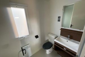 ein Bad mit einem Waschbecken, einem WC und einem Fenster in der Unterkunft Mobile Home OuiReves 113 facing the Mediterranean in Sète