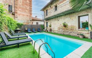 a swimming pool in a yard with two chairs and a building at Maison Des Reves in Viarigi