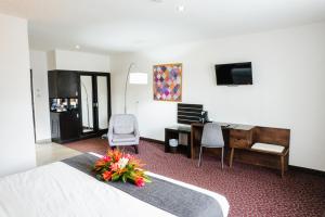 a hotel room with a bedroom with a desk and a bed at KC Hotel San Jose in San José
