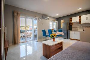 a room with a bed and a kitchen with a table at Apartments Hudovernik in Baška Voda
