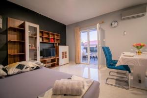 a bedroom with a bed and a table and a chair at Apartments Hudovernik in Baška Voda