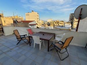 un tavolo e sedie sul tetto di un edificio di Terrace Roof Room @ Koridallos Metro St. & Piraeus Port a Pireo