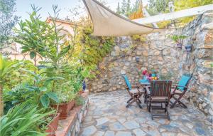 a patio with a table and chairs and a stone wall at 3 Bedroom Beautiful Home In Almuñecar in Almuñécar