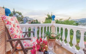 a chair sitting on a balcony with flowers and wine glasses at 3 Bedroom Beautiful Home In Almuñecar in Almuñécar